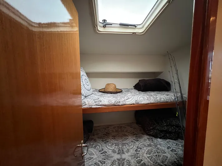 Todo Bien Yacht Photos Pics Cozy cabin interior of 2000 Viking 58 Enclosed Bridge with patterned bedding and skylight.