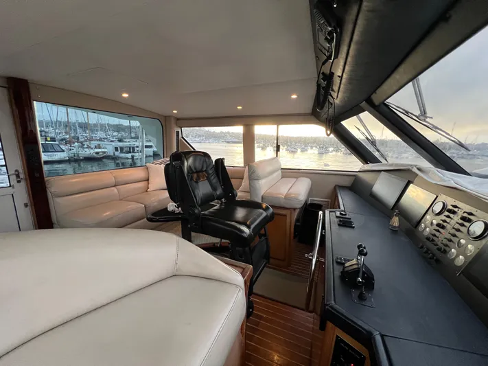 Todo Bien Yacht Photos Pics Interior of 2000 Viking 58 Enclosed Bridge yacht with luxurious seating and control panel.