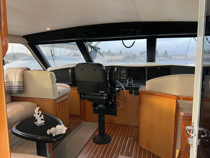 Todo Bien Yacht Photos Pics 2000 Viking 58 Enclosed Bridge yacht interior with helm, seating, and wooden flooring.