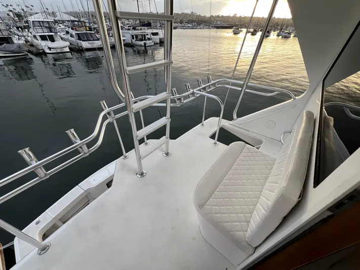 Todo Bien Yacht Photos Pics 2000 Viking 58 Enclosed Bridge yacht deck with seating, overlooking marina at sunset.
