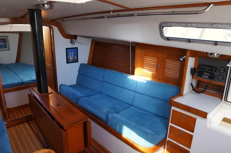  Yacht Photos Pics Interior of 2007 J Boats J/124 sailboat with blue seating and wooden cabinetry.
