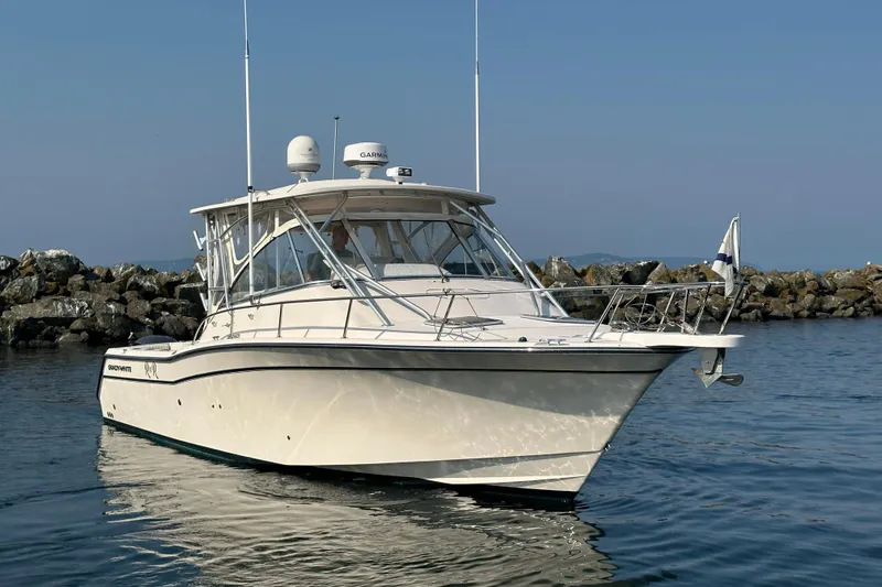 R & R Yacht Photos Pics 2008 Grady White Express boat on calm water near rocky shoreline.