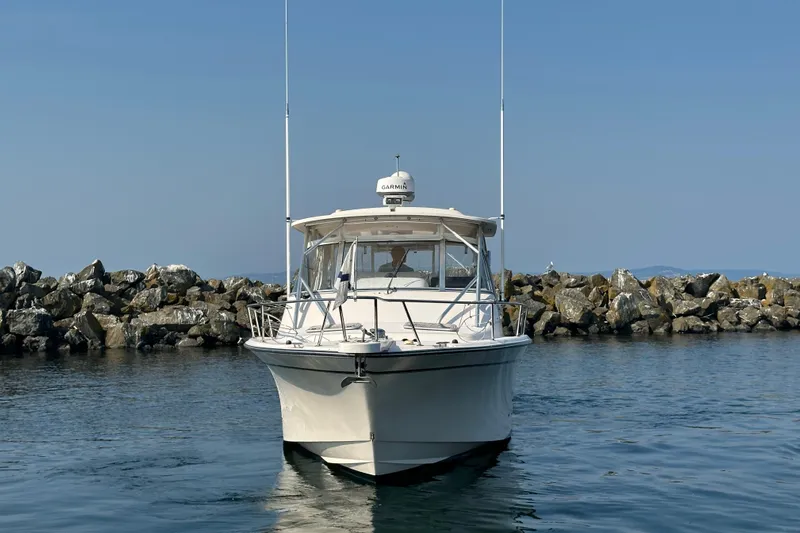R & R Yacht Photos Pics 2008 Grady White Express boat on calm water near rocky shoreline.