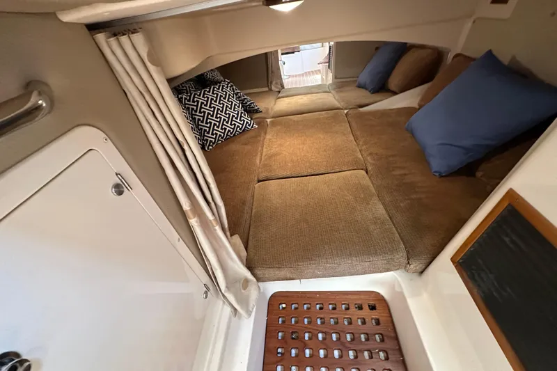 R & R Yacht Photos Pics 2008 Grady White Express cabin interior with cozy bedding and decorative pillows.