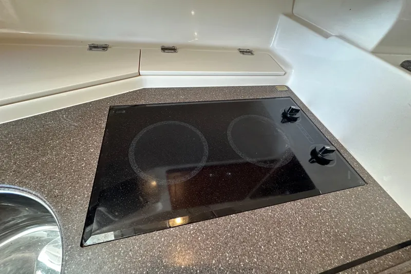 R & R Yacht Photos Pics 2008 Grady White Express boat kitchen with electric stovetop and sleek countertop.