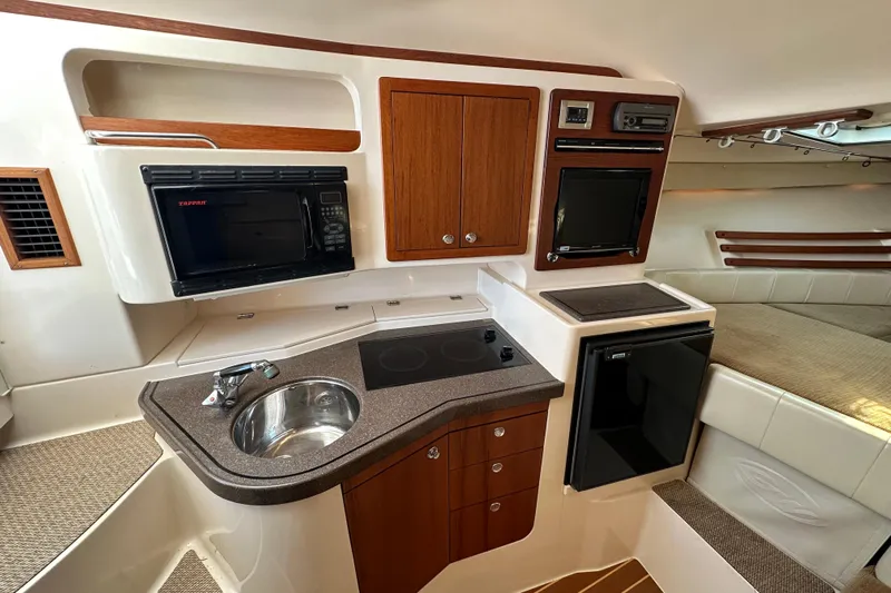 R & R Yacht Photos Pics 2008 Grady White Express boat interior with kitchenette, featuring sink, microwave, and compact fridge.