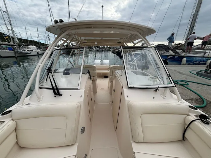 Sweetness Yacht Photos Pics 2021 Grady-White Freedom 285 boat docked at marina, showcasing spacious seating and helm.