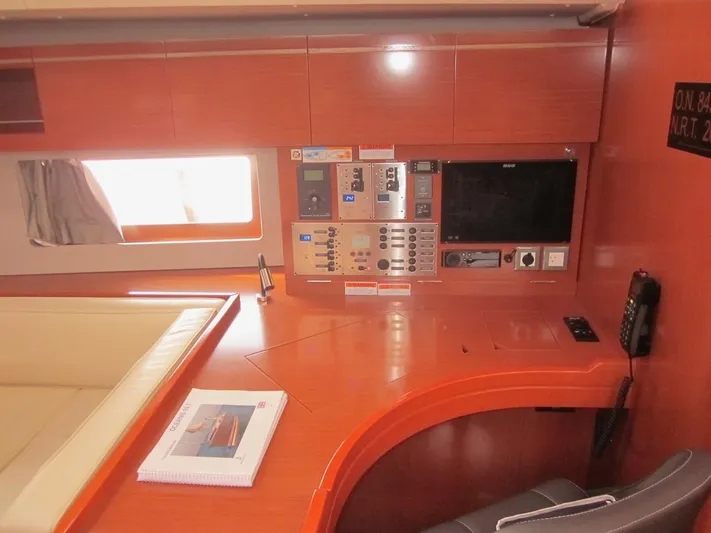 Cameli Yacht Photos Pics Navigation station in a 2020 Beneteau Oceanis 55 yacht with control panels and seating.