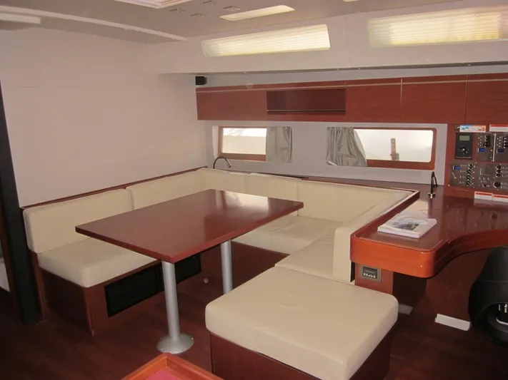 Cameli Yacht Photos Pics Interior of 2020 Beneteau Oceanis 55 yacht with beige seating and wooden table.