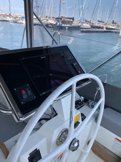 Cameli Yacht Photos Pics Cockpit view of 2020 Beneteau Oceanis 55 sailboat with steering wheel and navigation display.