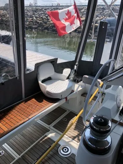 Cameli Yacht Photos Pics 2020 Beneteau Oceanis 55 cockpit with Canadian flag, docked in a marina.