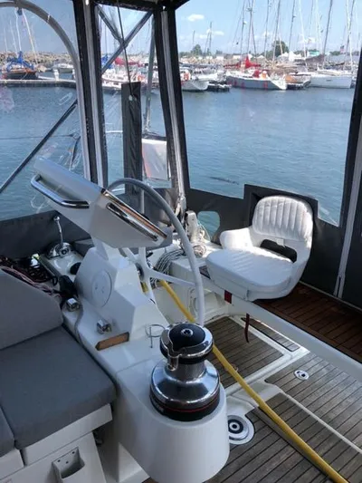 Cameli Yacht Photos Pics 2020 Beneteau Oceanis 55 yacht cockpit with marina view, featuring helm and seating area.