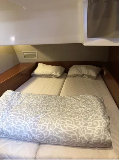 Cameli Yacht Photos Pics Cozy cabin interior of 2020 Beneteau Oceanis 55 yacht with twin beds and patterned bedding.