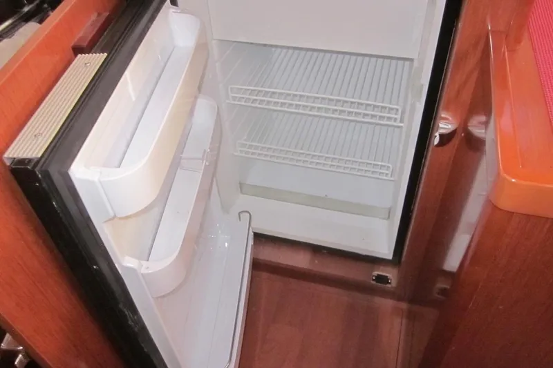 Cameli Yacht Photos Pics Open refrigerator inside 2020 Beneteau Oceanis 55 yacht, showcasing interior storage space.