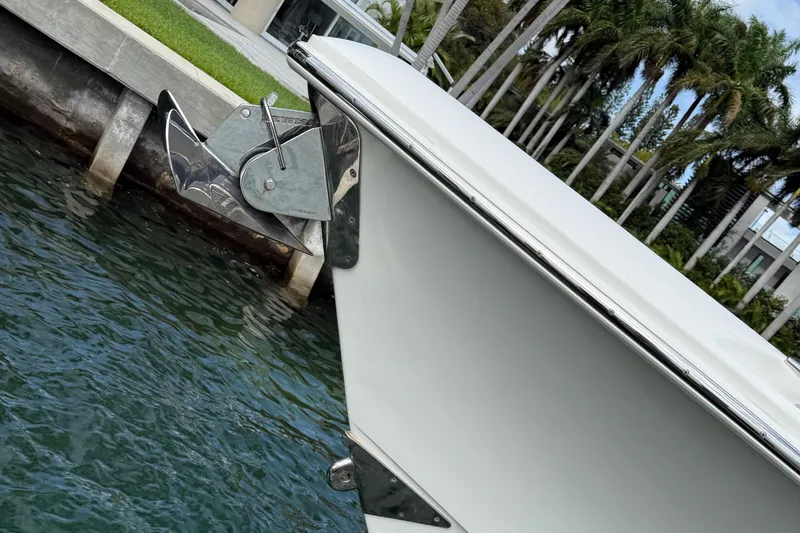  Yacht Photos Pics 2020 Boston Whaler 330 Outrage docked near palm trees and modern house.