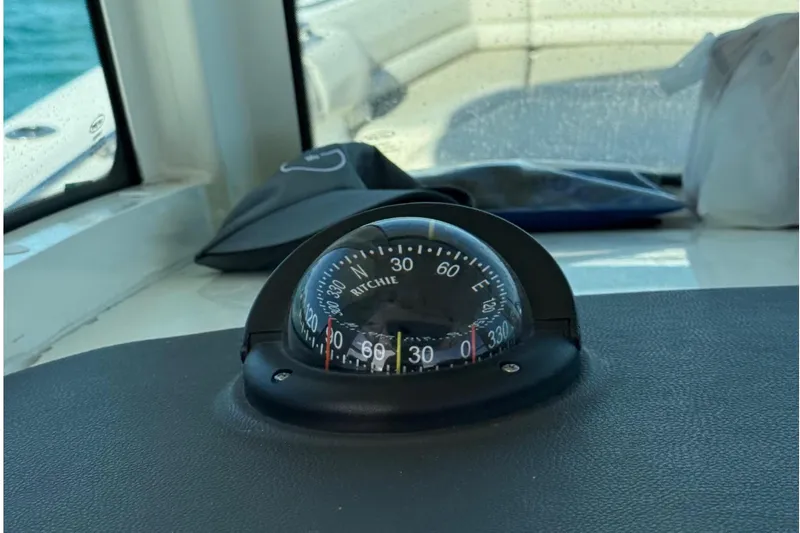  Yacht Photos Pics Compass on 2020 Boston Whaler 330 Outrage dashboard, overlooking calm blue waters.