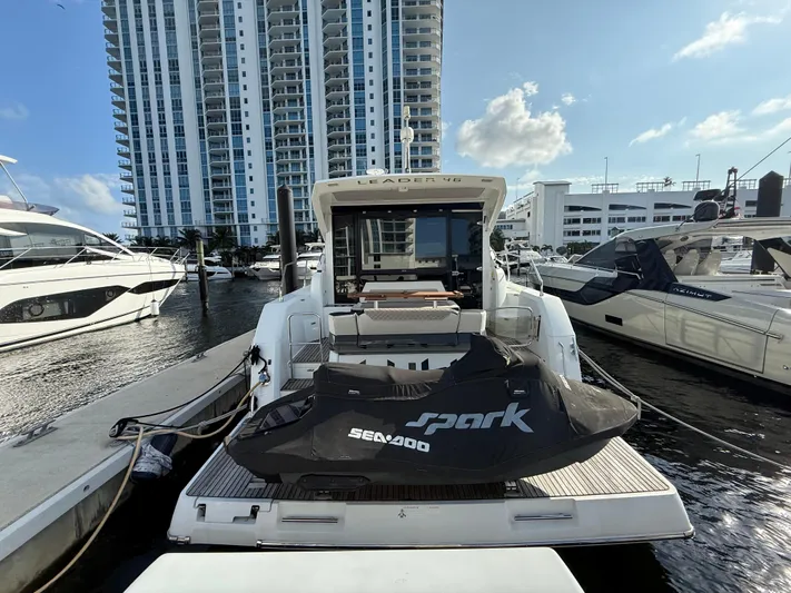 Luli Yacht Photos Pics 2017 Jeanneau Leader 46 yacht docked with Sea-Doo Spark jet ski, city skyline background.