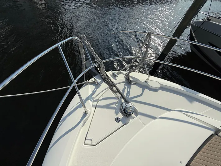 Luli Yacht Photos Pics Jeanneau Leader 46 bow, 2017 model, with anchor and railing, on calm water.