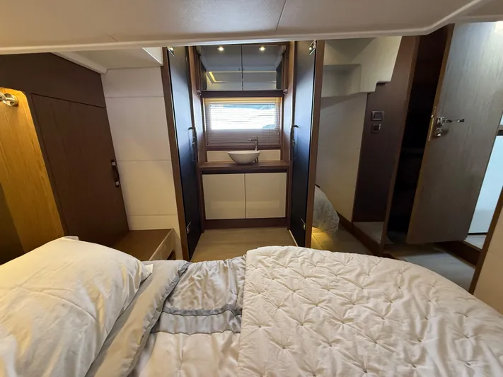 Luli Yacht Photos Pics Luxurious interior of 2017 Jeanneau Leader 46 yacht cabin with bed and ensuite bathroom.
