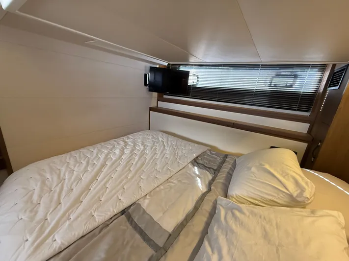 Luli Yacht Photos Pics Luxurious bedroom interior of 2017 Jeanneau Leader 46 yacht with TV and cozy bedding.