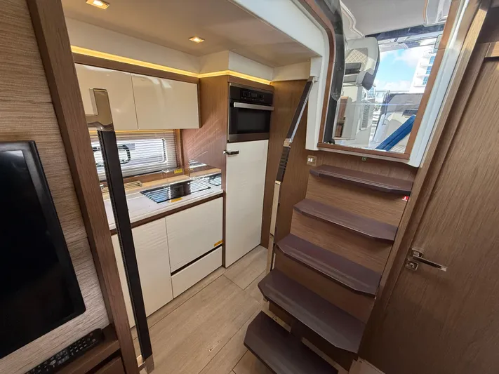 Luli Yacht Photos Pics Interior of 2017 Jeanneau Leader 46 yacht, featuring modern kitchen and wooden stairs.