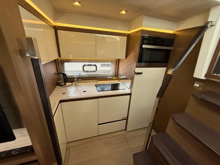 Luli Yacht Photos Pics Modern kitchen interior of 2017 Jeanneau Leader 46 yacht with sleek cabinetry and appliances.