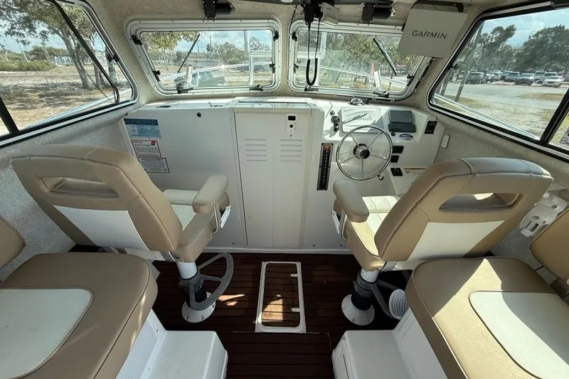  Yacht Photos Pics 2019 Parker 2520 XLD Sport Cabin interior with steering wheel and beige seating.
