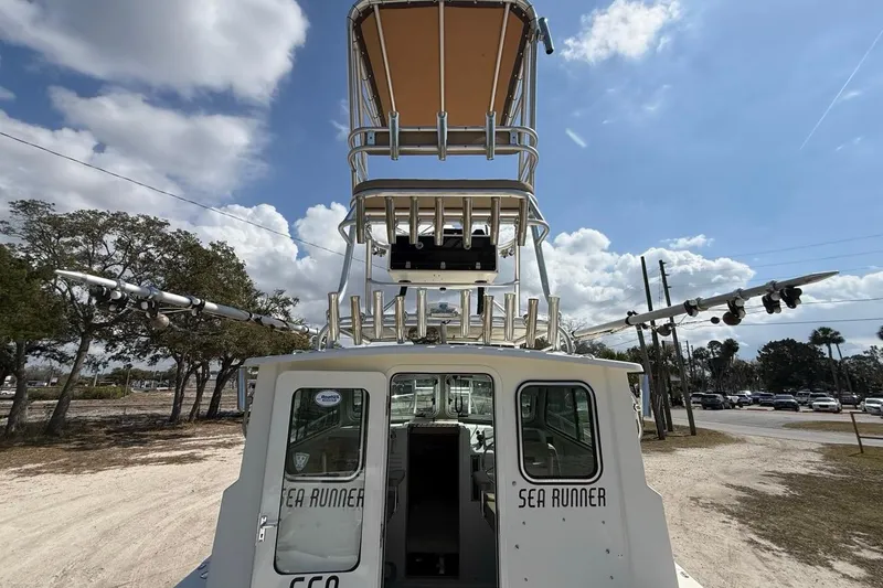  Yacht Photos Pics 2019 Parker 2520 XLD Sport Cabin boat with tower, parked outdoors under a cloudy sky.