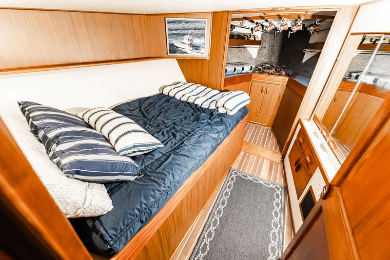 Leslie Ann Yacht Photos Pics Cozy cabin interior of 1988 Buddy Davis 47 Convertible yacht with bed and wooden cabinetry.