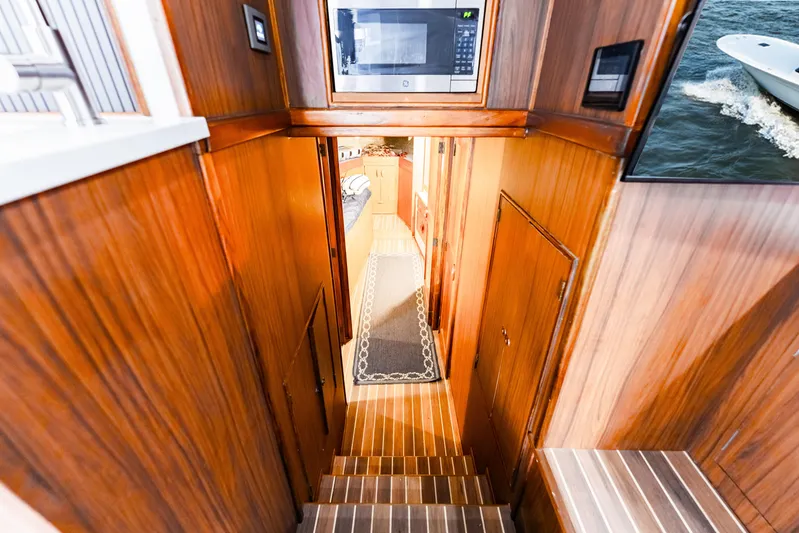Leslie Ann Yacht Photos Pics Interior view of 1988 Buddy Davis 47 Convertible yacht with wooden paneling and stairs.