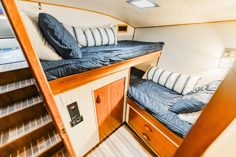 Leslie Ann Yacht Photos Pics Cozy cabin interior of 1988 Buddy Davis 47 Convertible yacht with bunk beds and striped pillows.