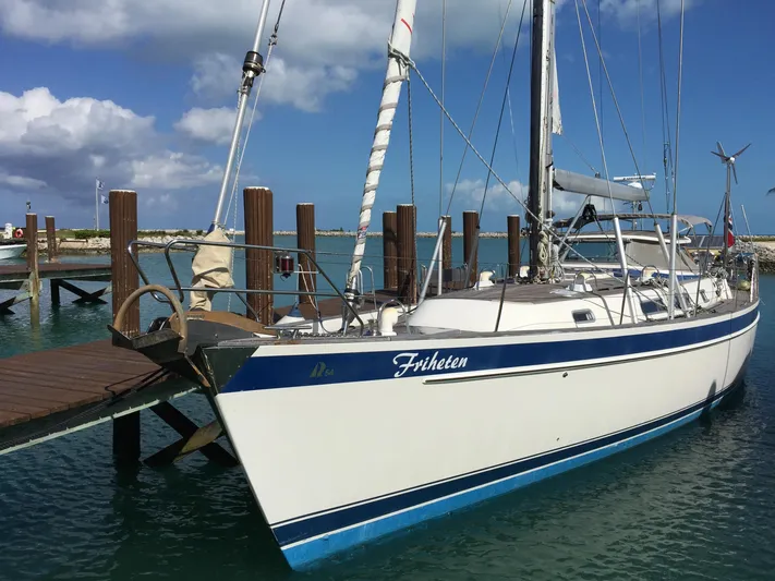 Friheten Yacht Photos Pics 2009 Hallberg-Rassy 54 sailboat docked at a marina under a blue sky.
