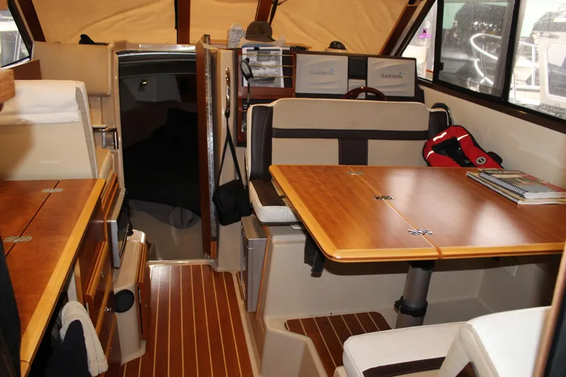  Yacht Photos Pics Interior of 2016 Cutwater 30 Command Bridge with wood accents and seating area.