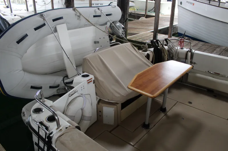  Yacht Photos Pics 2016 Cutwater 30 Command Bridge boat with wooden table and inflatable dinghy in docked setting.