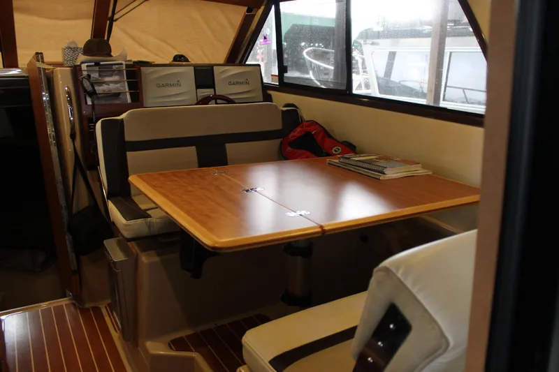  Yacht Photos Pics Interior of 2016 Cutwater 30 Command Bridge with dining table and seating area.