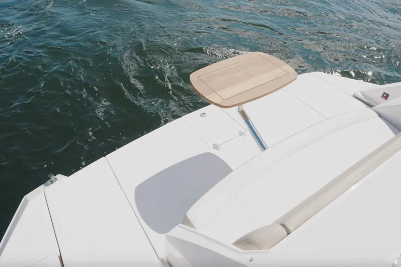 Life Is Good Yacht Photos Pics 2017 Regal 53 Sport Coupe yacht deck with table, overlooking water.