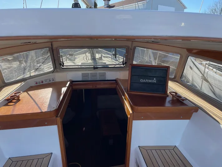 Friheten Yacht Photos Pics 2009 Hallberg-Rassy 54 yacht cockpit with Garmin navigation system, featuring wooden accents and large windows.