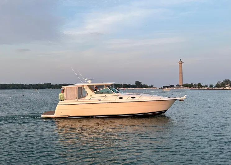 Nice Aft Yacht Photos Pics 1998 Tiara Yachts 4000 Express cruising near a coastal monument at sunset.