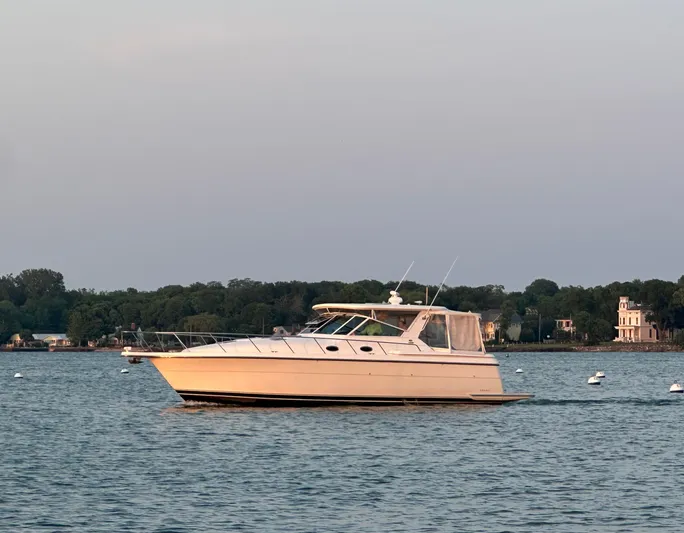 Nice Aft Yacht Photos Pics 1998 Tiara Yachts 4000 Express cruising on a calm lake with scenic shoreline.