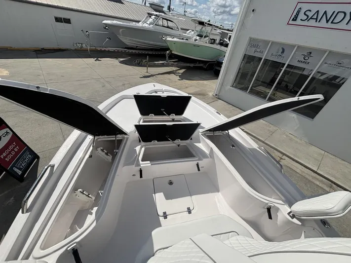  Yacht Photos Pics 2025 Sea Fox 251 Bay Fox boat with open storage compartments, displayed at a dealership.