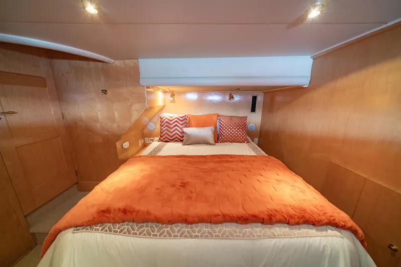 Altitude Adjustment Yacht Photos Pics Cozy bedroom in 2000 Navigator 5300 Classic yacht with orange bedding and wooden walls.