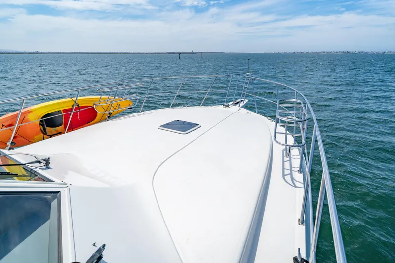 Altitude Adjustment Yacht Photos Pics Bow of 2000 Navigator 5300 Classic yacht with kayak, on open water under blue sky.