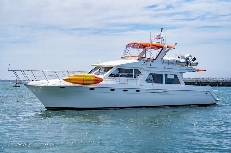Altitude Adjustment Yacht Photos Pics 2000 Navigator 5300 Classic yacht with kayaks on deck, cruising in calm waters.
