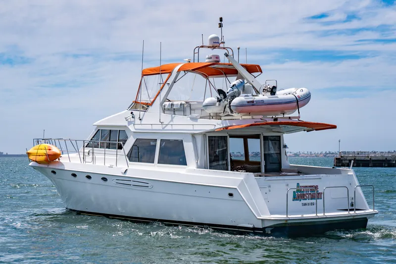 Altitude Adjustment Yacht Photos Pics 2000 Navigator 5300 Classic yacht with orange canopy cruising in open water.