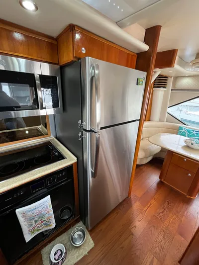Our Time Yacht Photos Pics 2001 Bayliner 5788 Pilot House Motoryacht kitchen with stainless steel appliances and dining area.