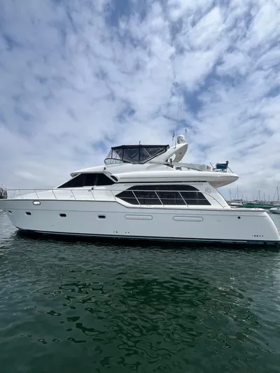 Our Time Yacht Photos Pics 2001 Bayliner 5788 Pilot House Motoryacht on water under cloudy sky.