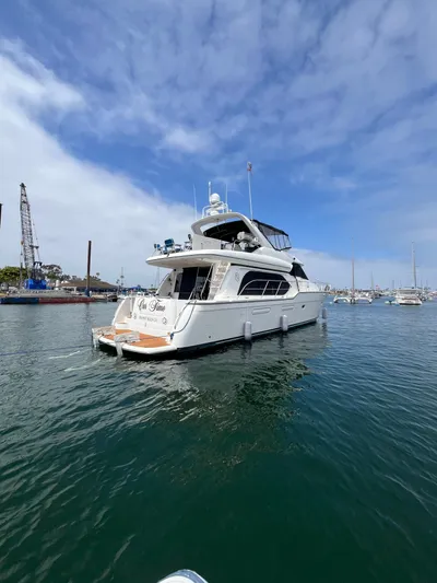 Our Time Yacht Photos Pics 2001 Bayliner 5788 Pilot House Motoryacht on calm water under a partly cloudy sky.