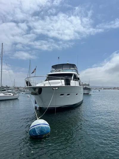 Our Time Yacht Photos Pics 2001 Bayliner 5788 Pilot House Motoryacht anchored in a serene harbor.