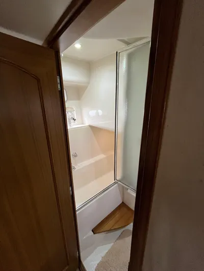 Our Time Yacht Photos Pics 2001 Bayliner 5788 Pilot House Motoryacht bathroom with shower and wooden accents.