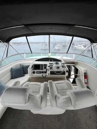 Our Time Yacht Photos Pics 2001 Bayliner 5788 Pilot House Motoryacht helm with plush seating and marina view.